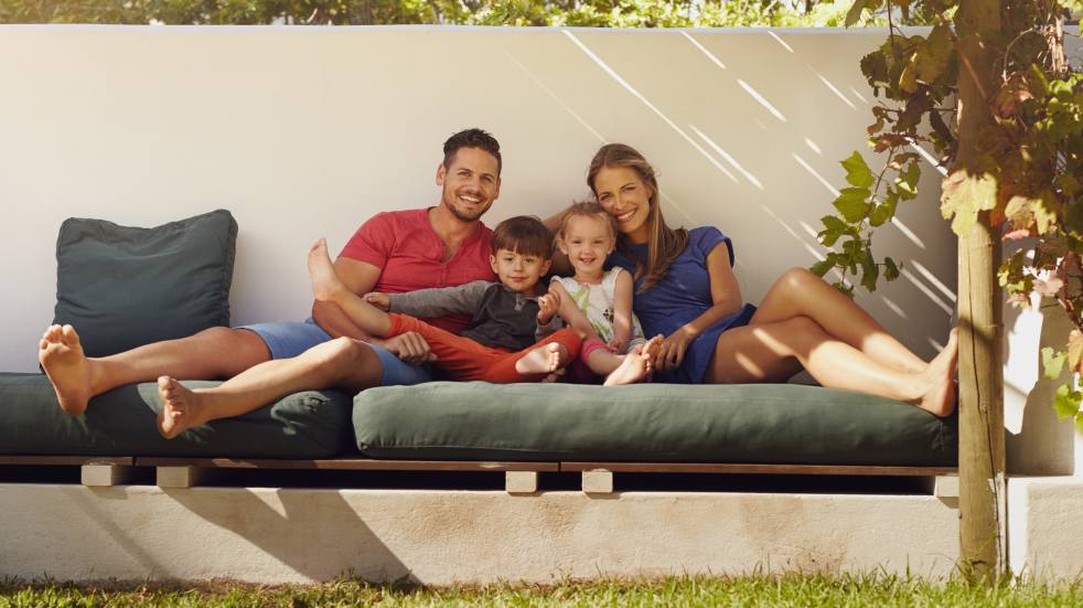 Family relaxing on garden furniture